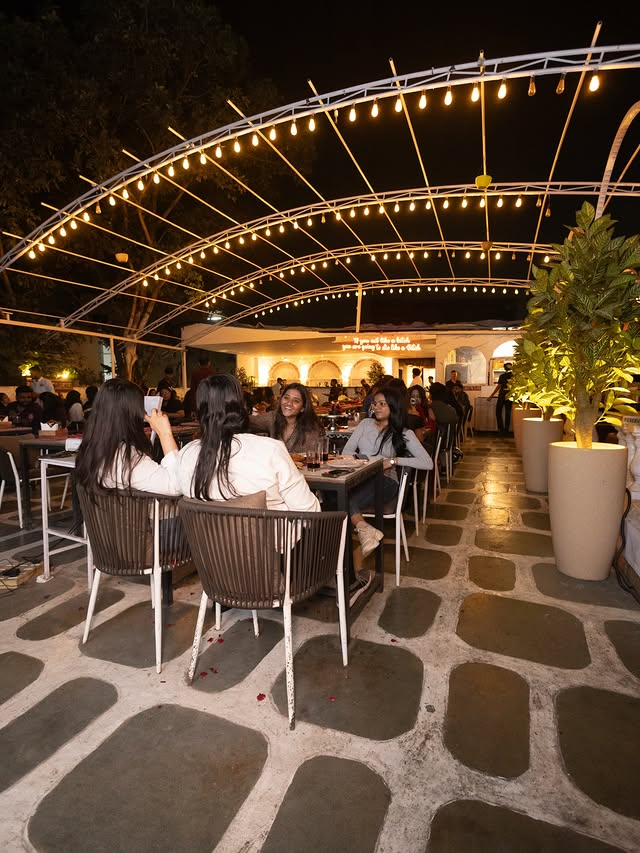 Friends at a table on the Skyline terrace under string lights