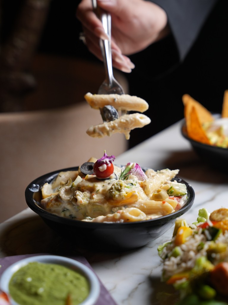 Penne in crème cheese sauce lifted on a fork
