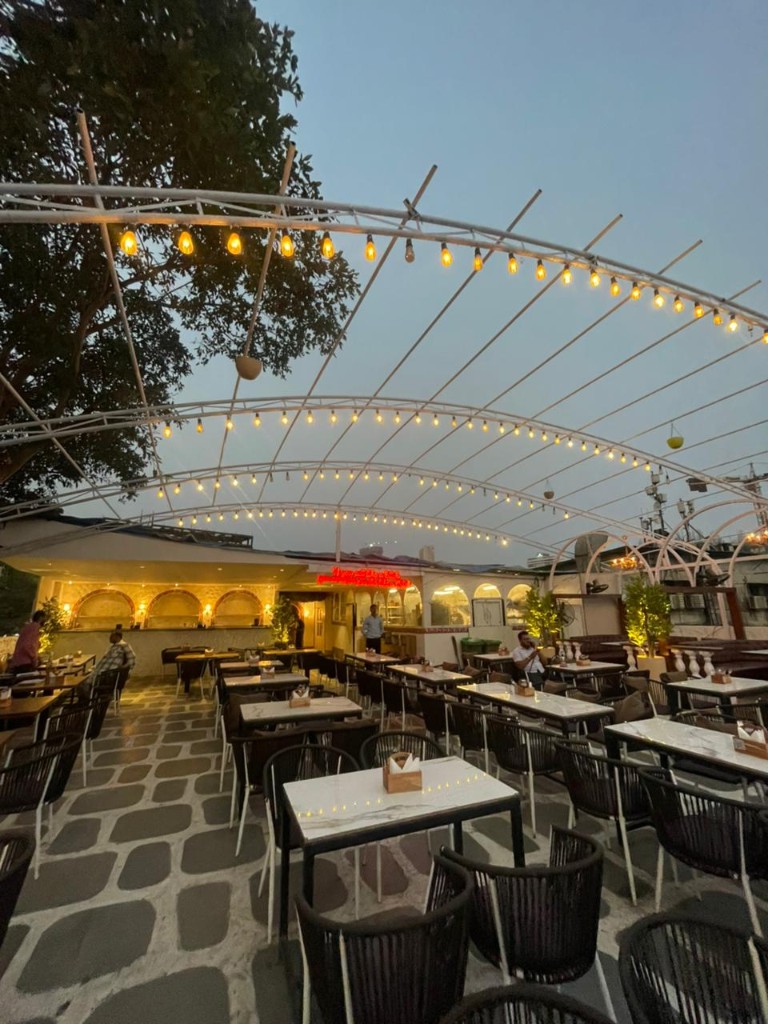 Marble tables set under the white canopy before service